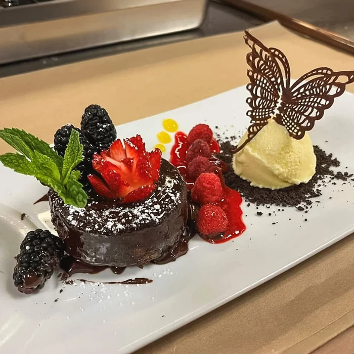 Chocolate dessert with fresh berries, featured on Aura’s restaurant page