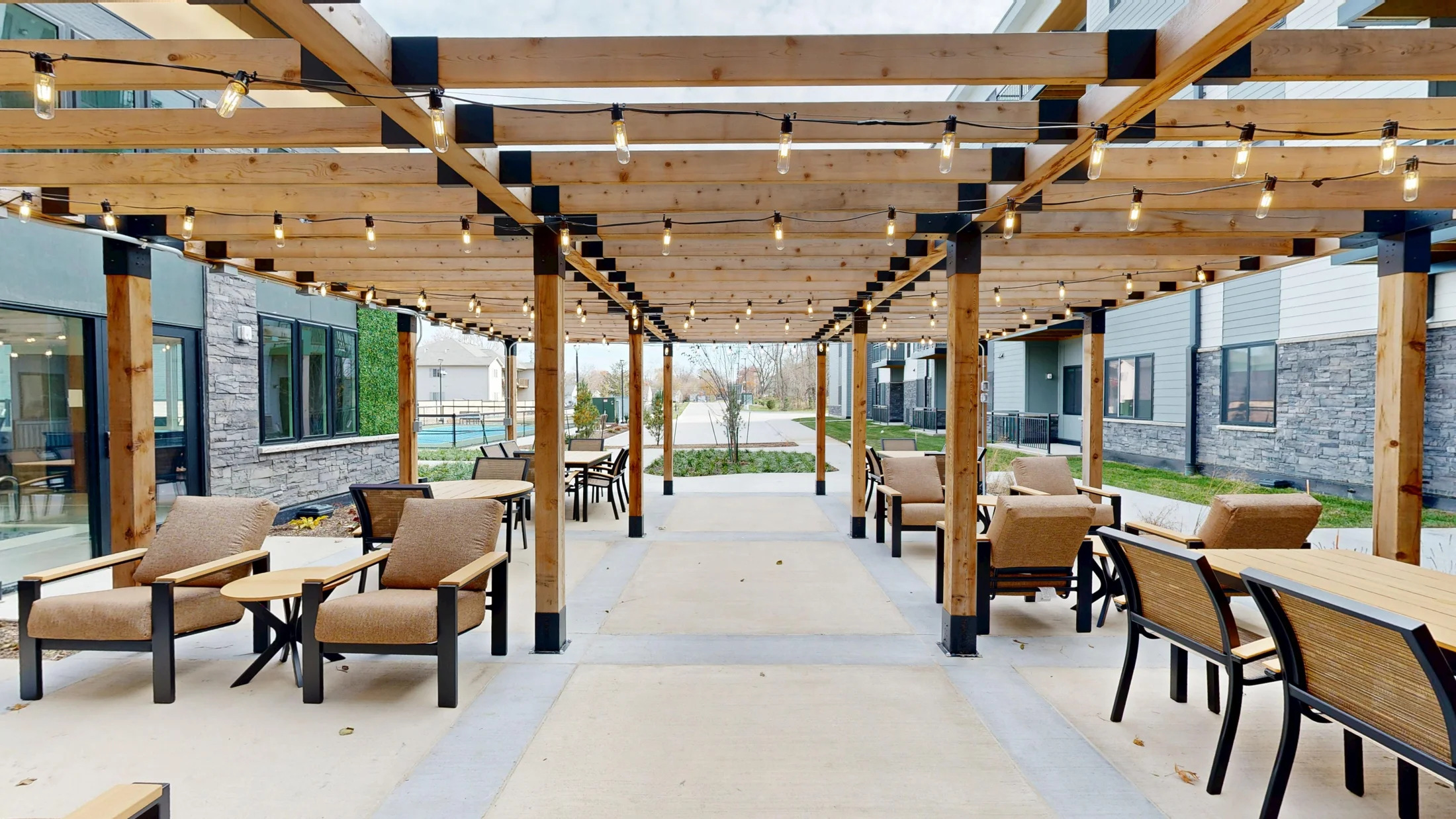 Outdoor terrace at Aura with tables beneath a timber pergola